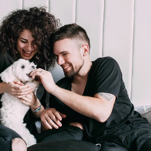 a man and a woman holding a dog